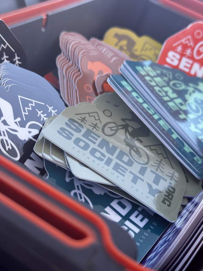 A bin full of Send It Society stickers